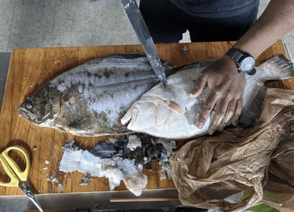 man cutting fresh fish
